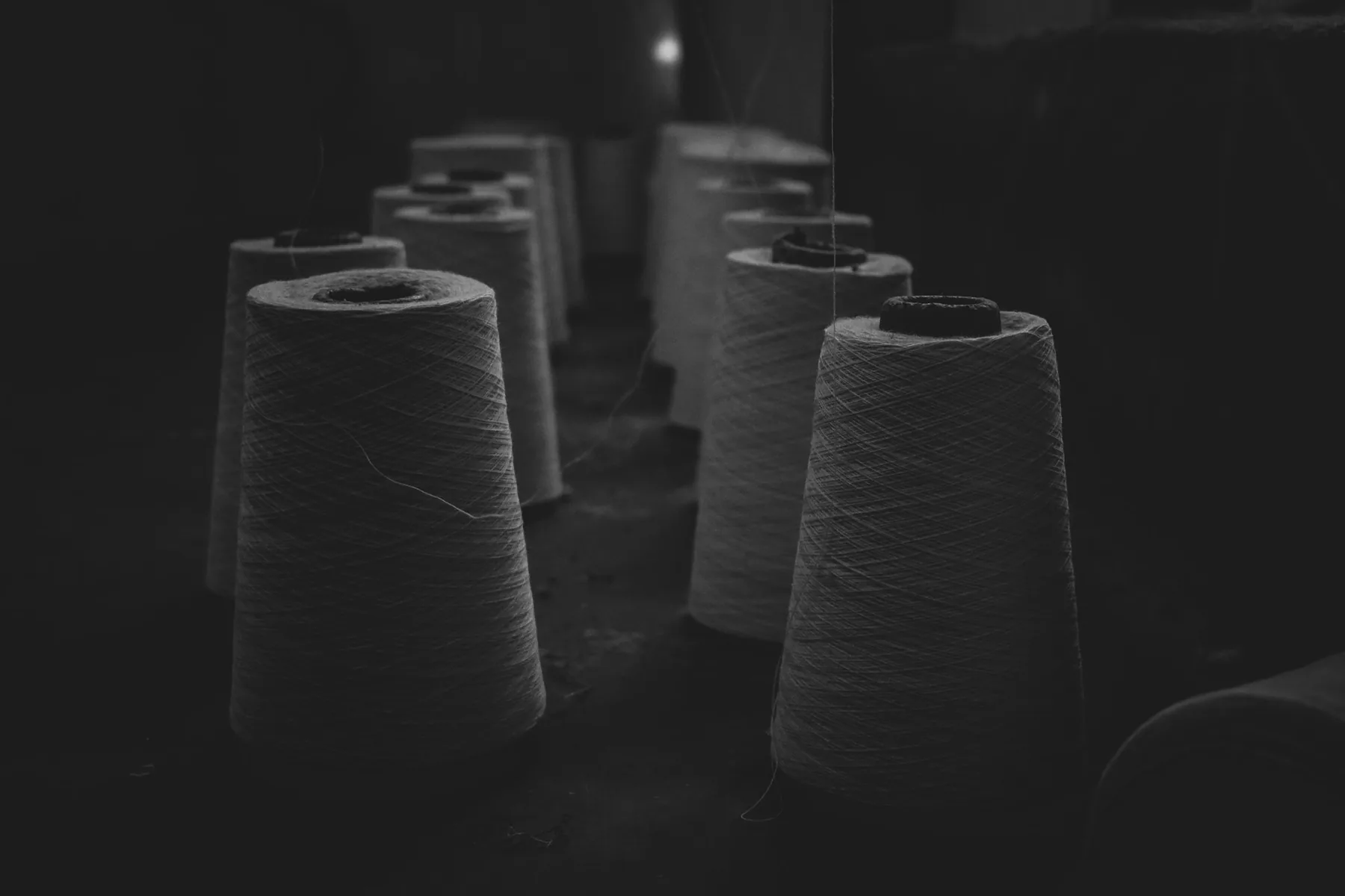 Cones of spun yarn photographed in low light