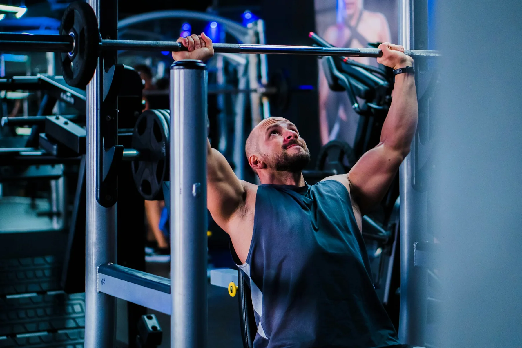 Athlete in a light training top holding a weight plate