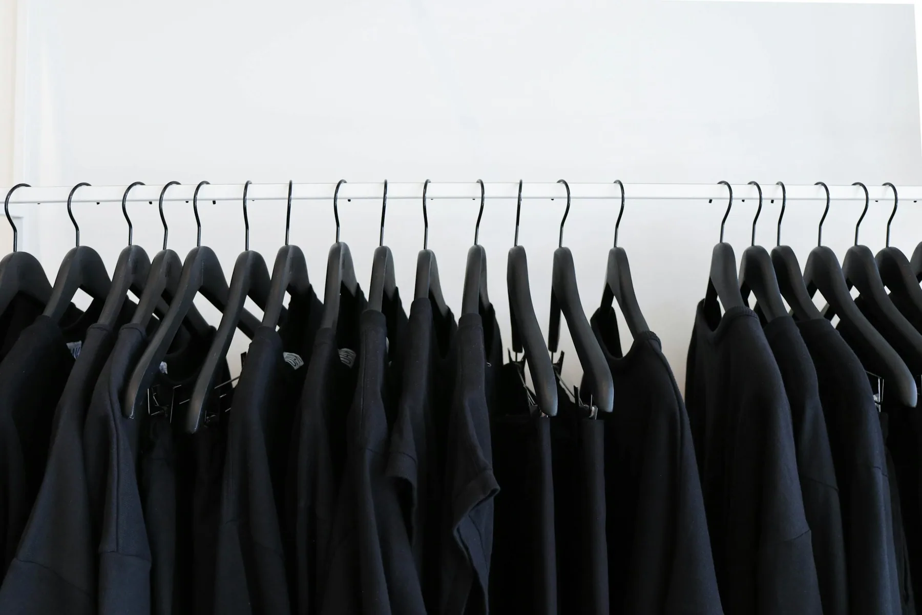 Dark garments hanging on a rail