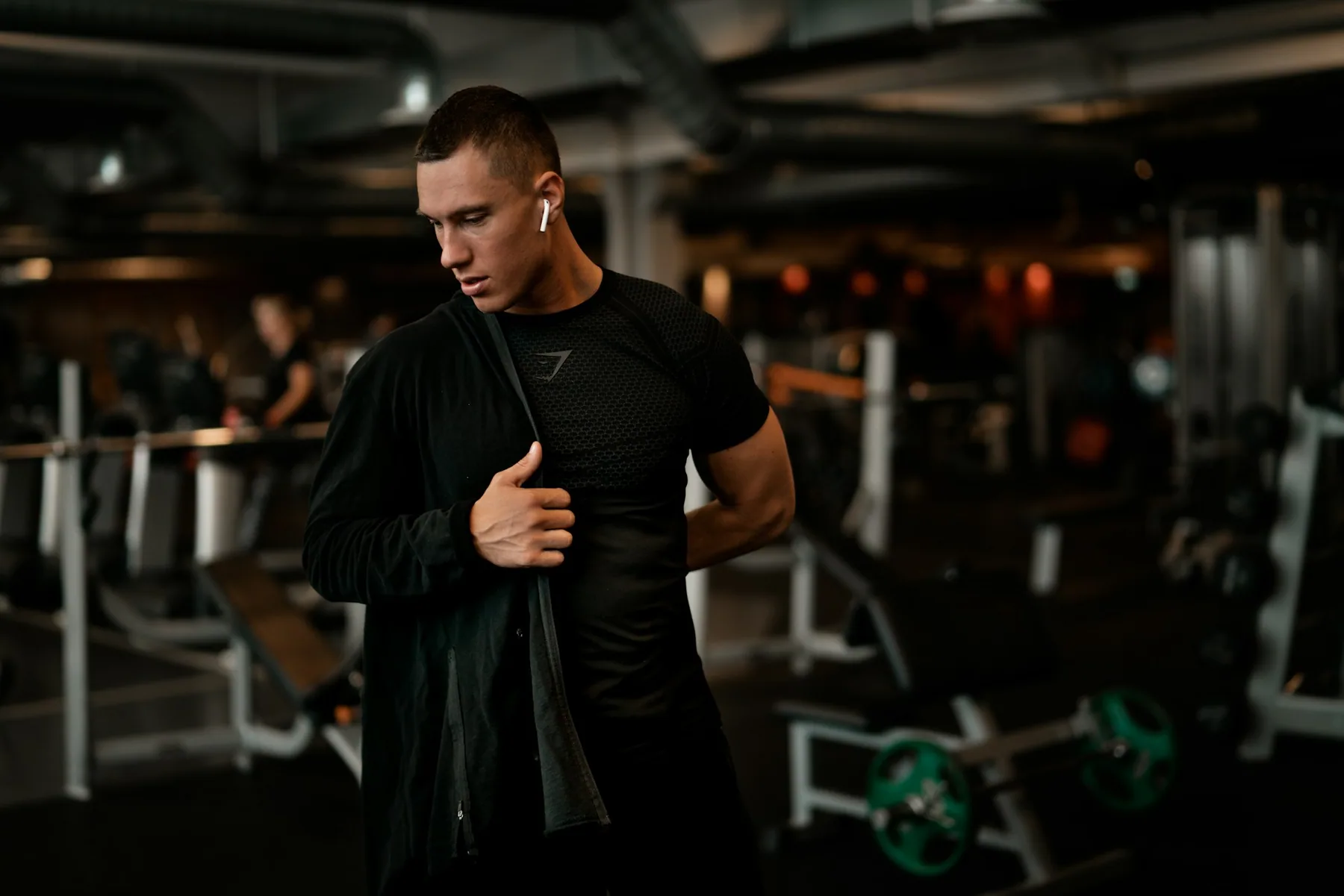 Athlete in a fitted black base layer in a dark gym