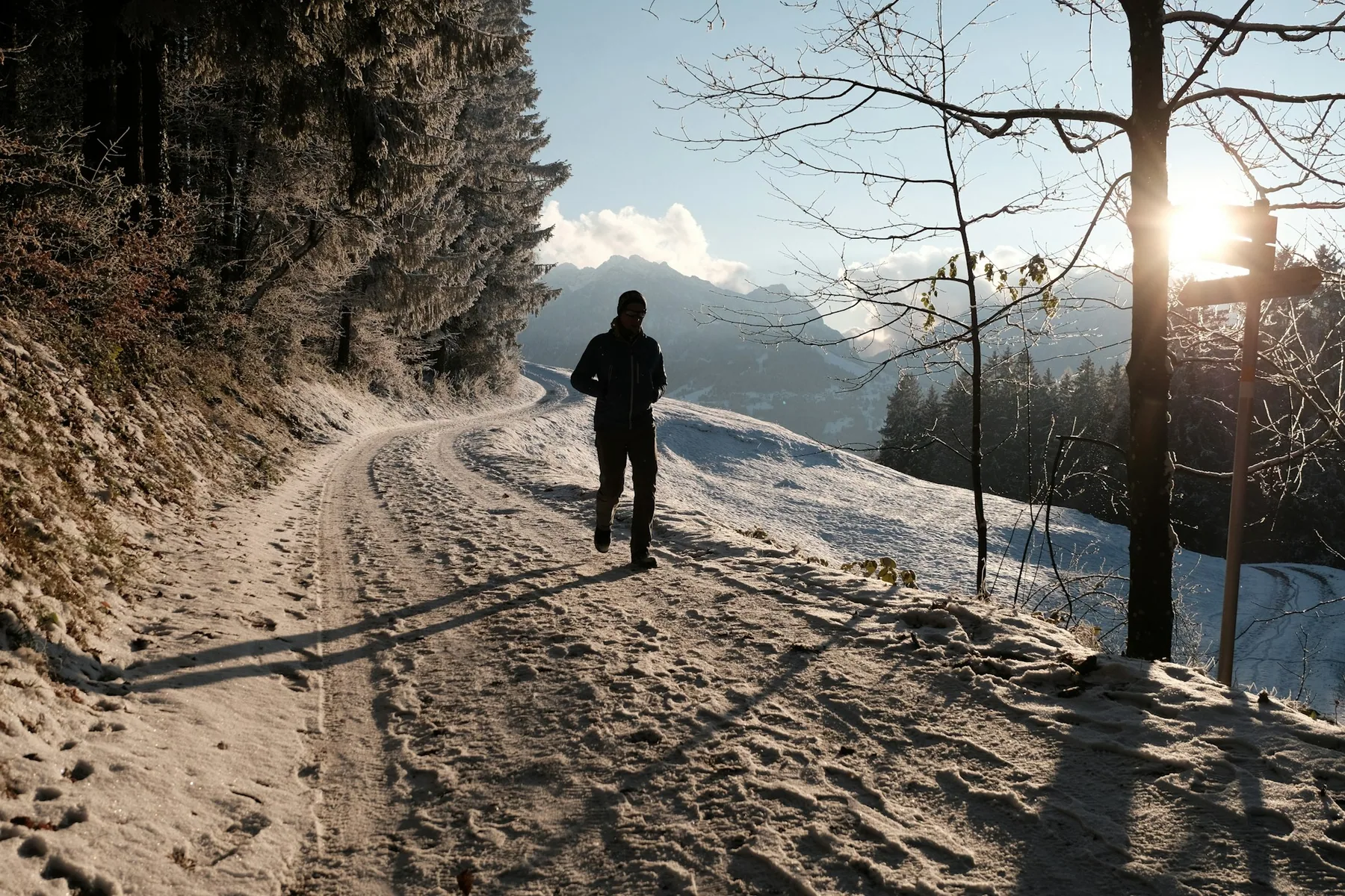 Lone runner on a hillside trail in cold conditions