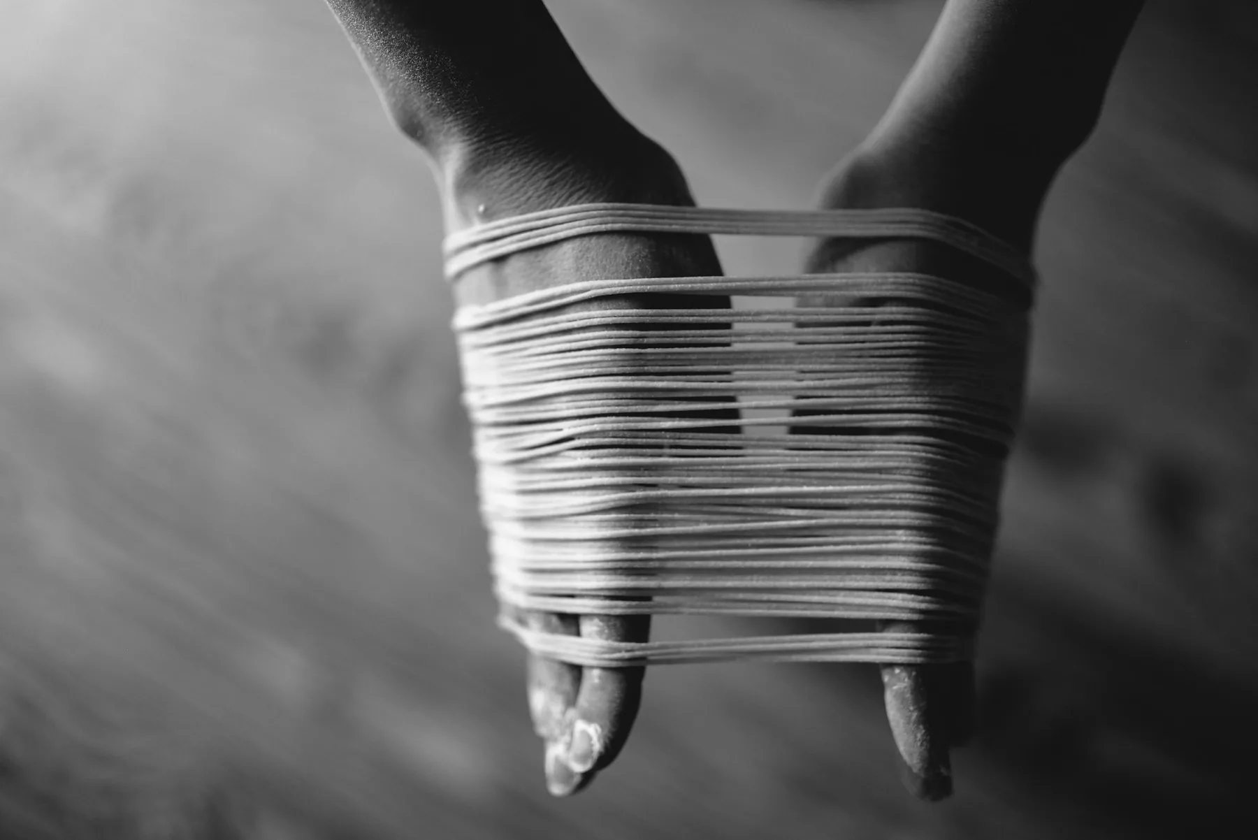 Grey fabric being stretched between two hands