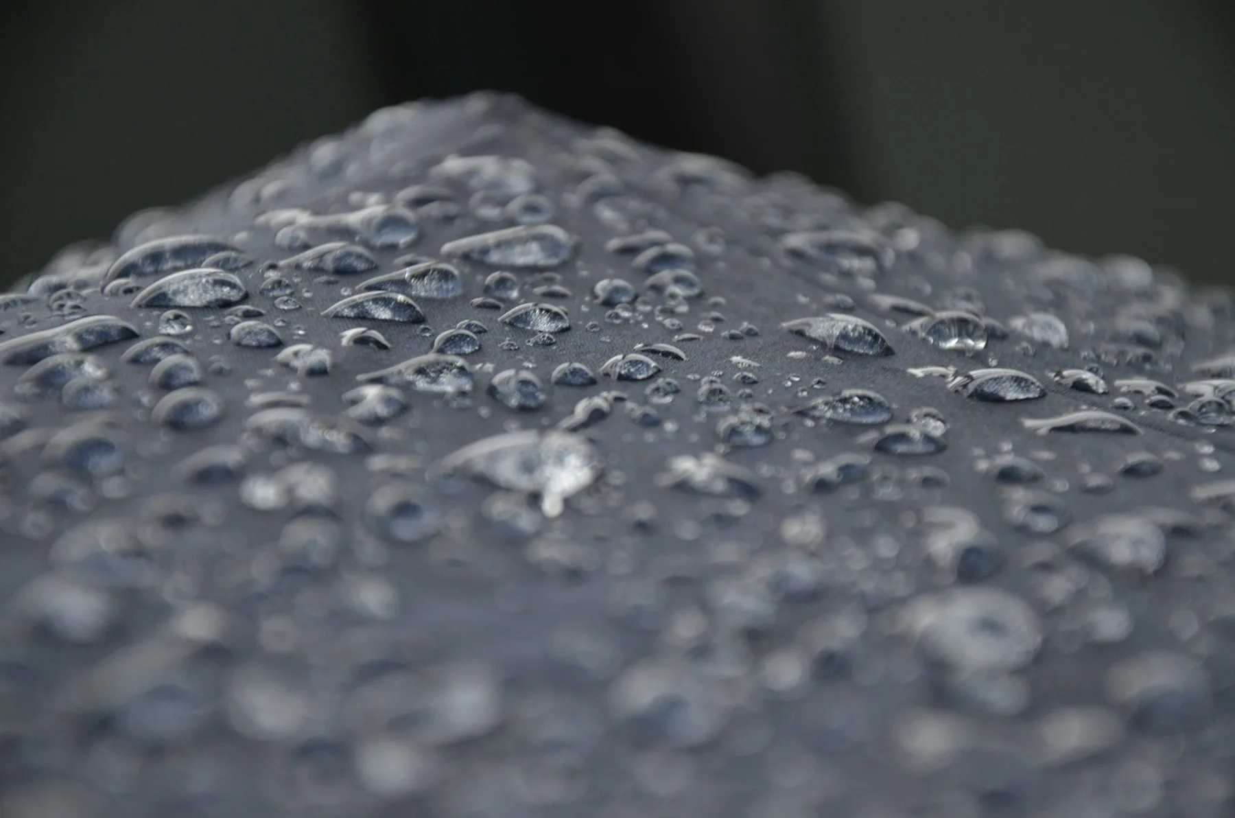 Water beading on a dark technical fabric