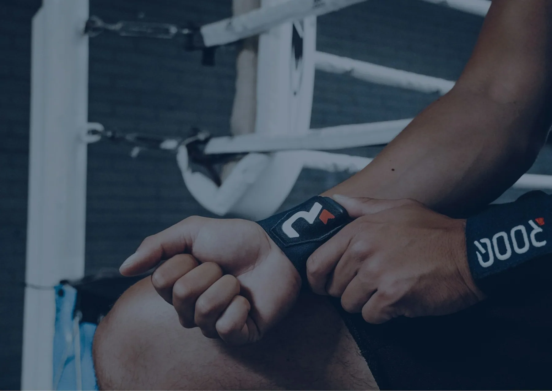 Wrist wraps being fastened in a dark gym