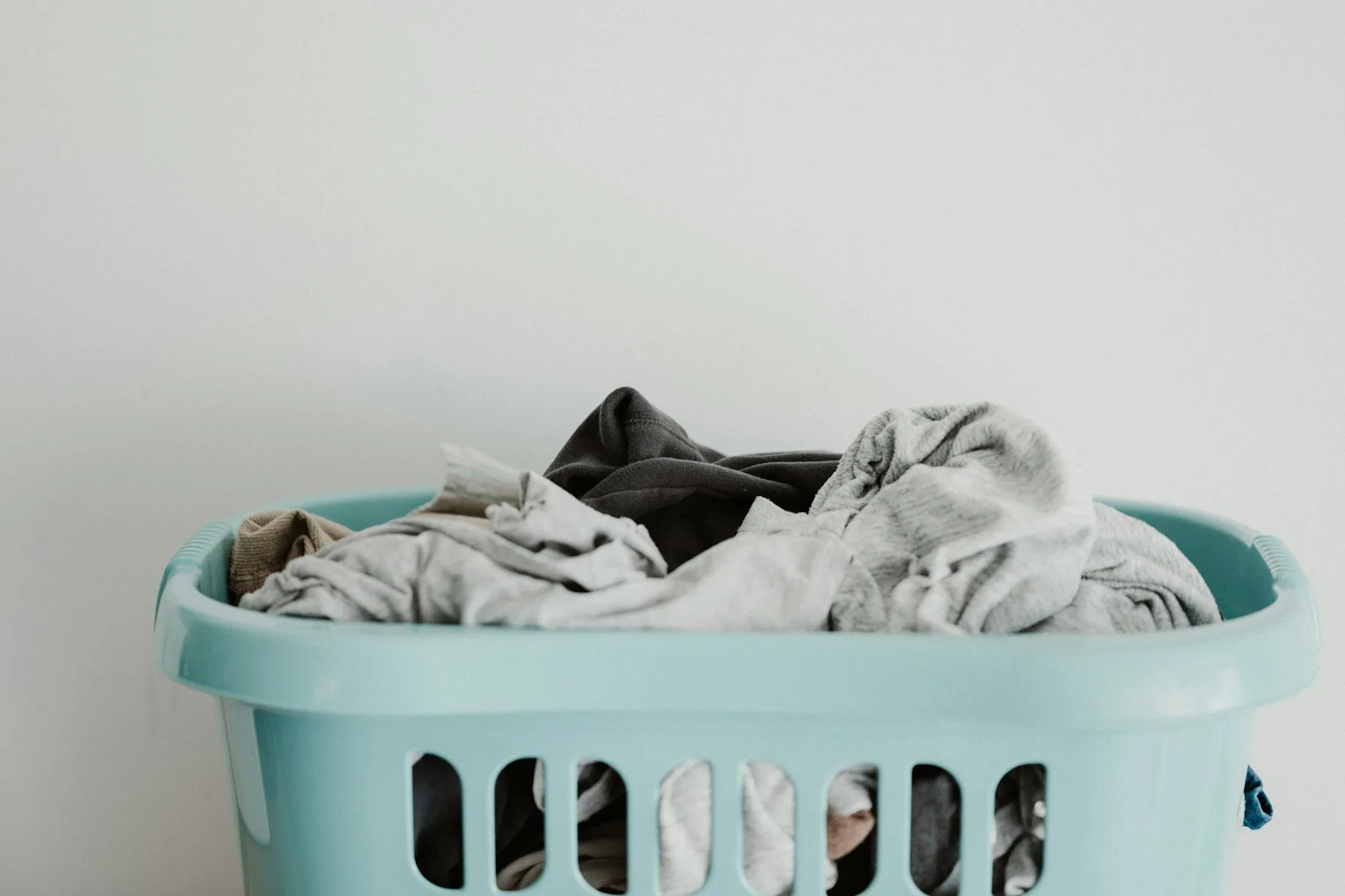 A basket of clothes against a plain wall