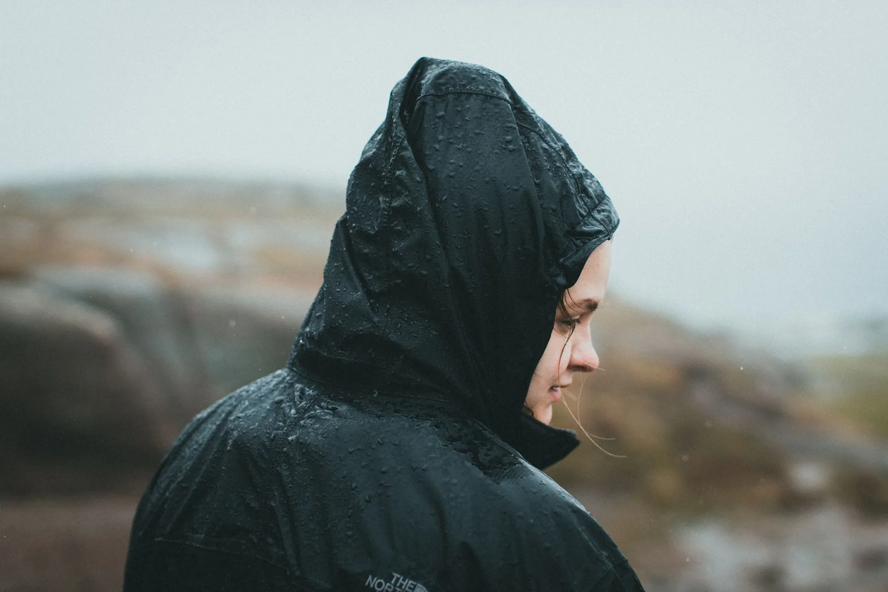 Runner in a mid-layer and beanie on a woodland path