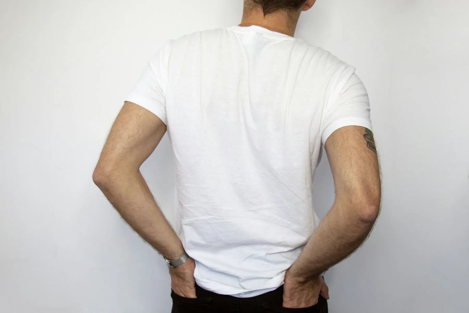 Rear view of a plain white t-shirt showing the back panel and shoulders