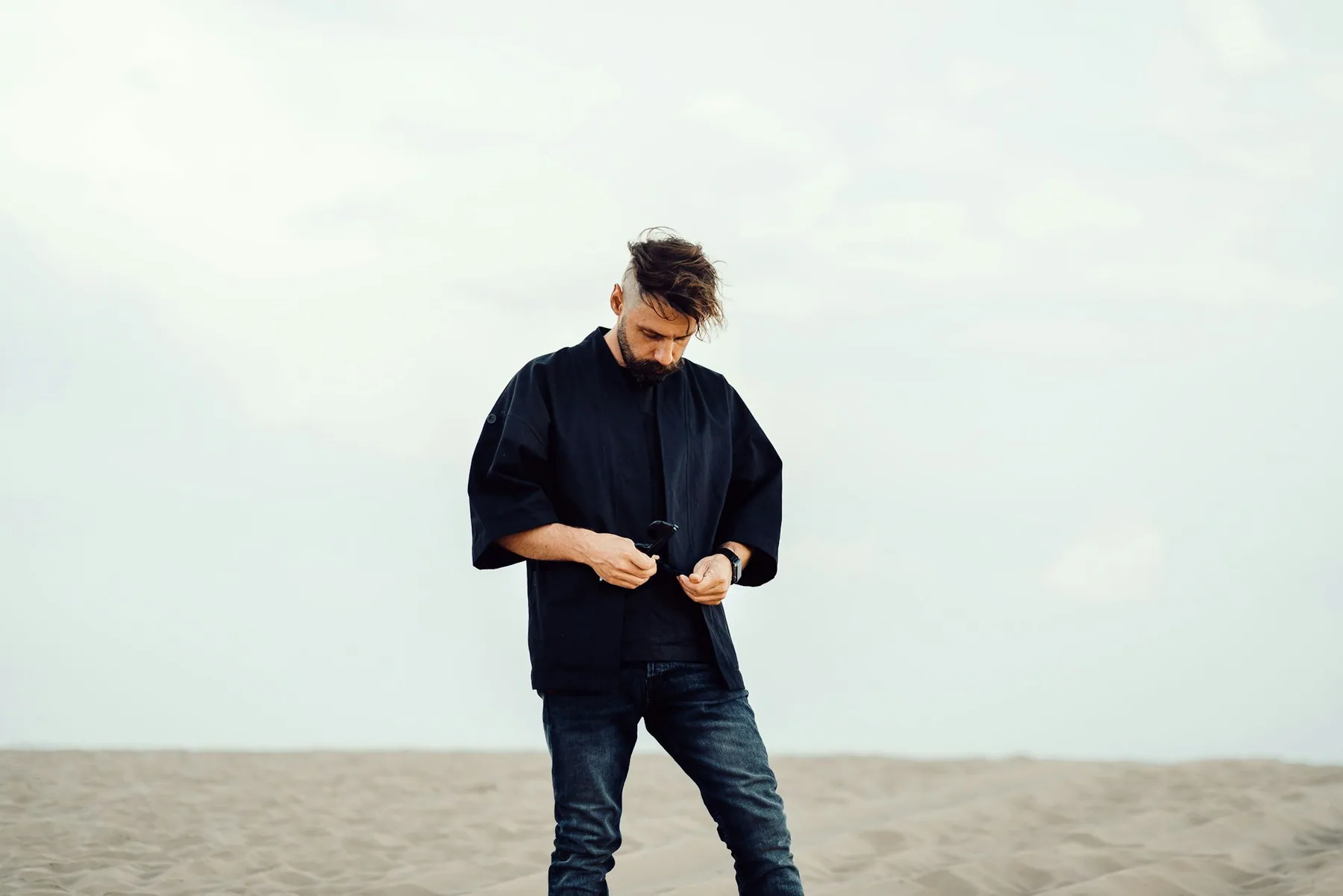 Man in an oversized black t-shirt against an open background