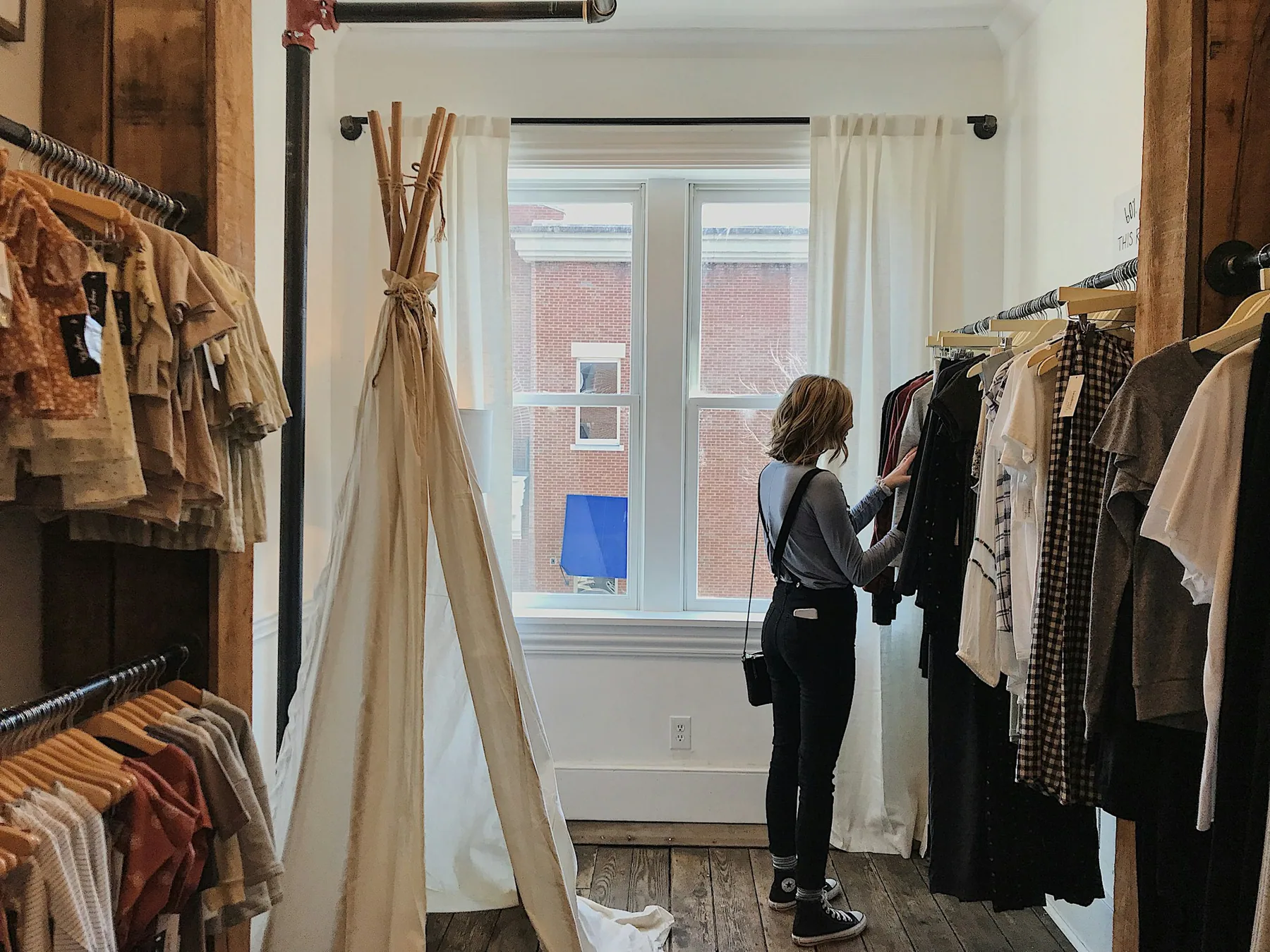 Someone browsing a rail in a muted interior