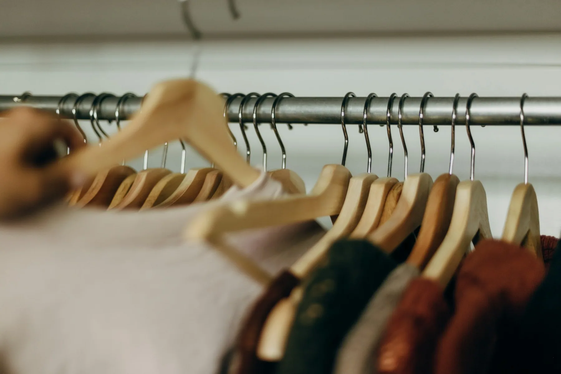 Wooden hangers on a clothing rail