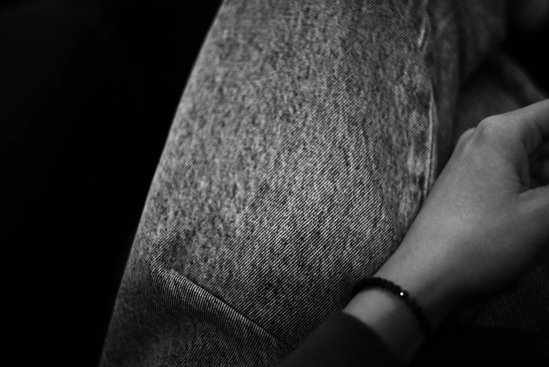 Hands examining a grey knit garment