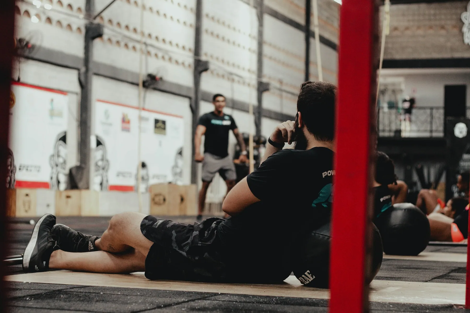 Athlete resting against a wall in a gym