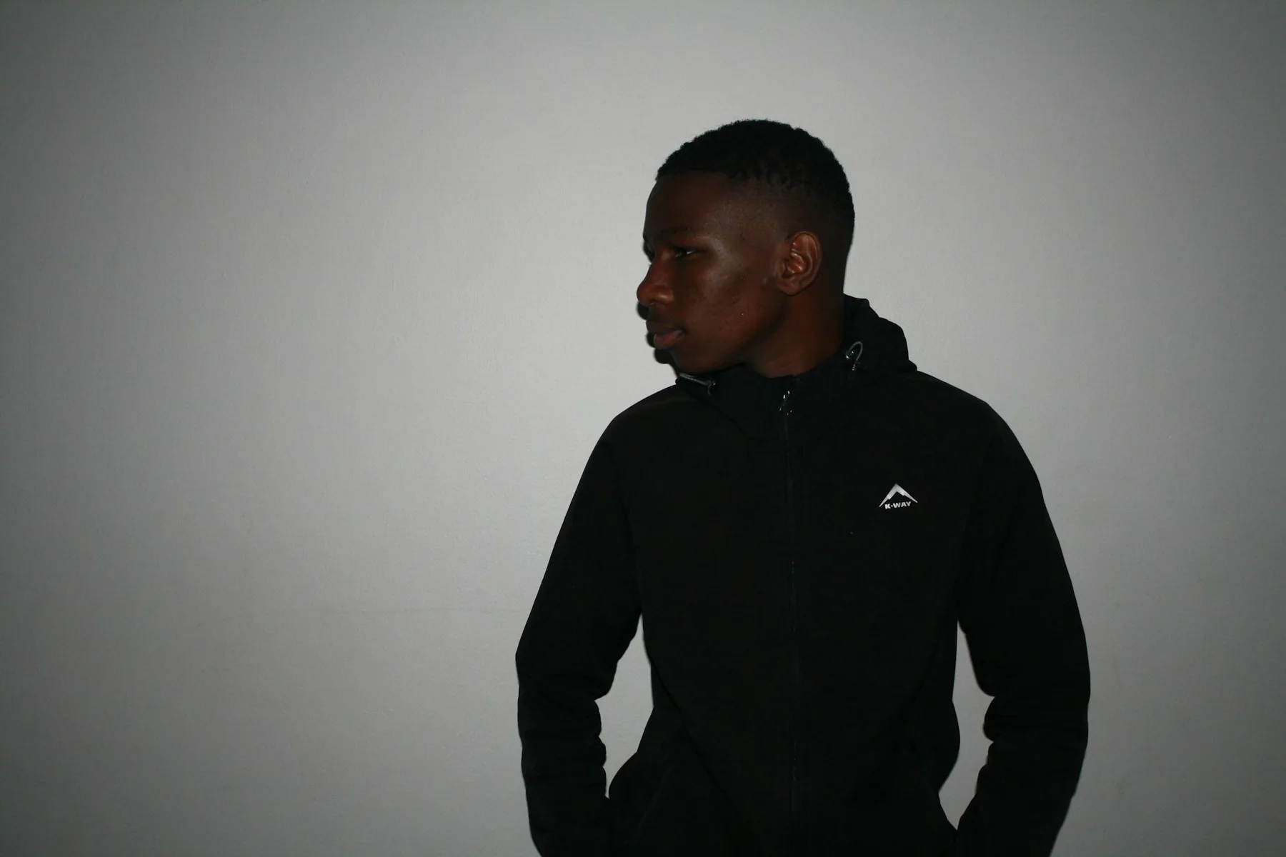 Athlete in a plain black hooded top against a grey background