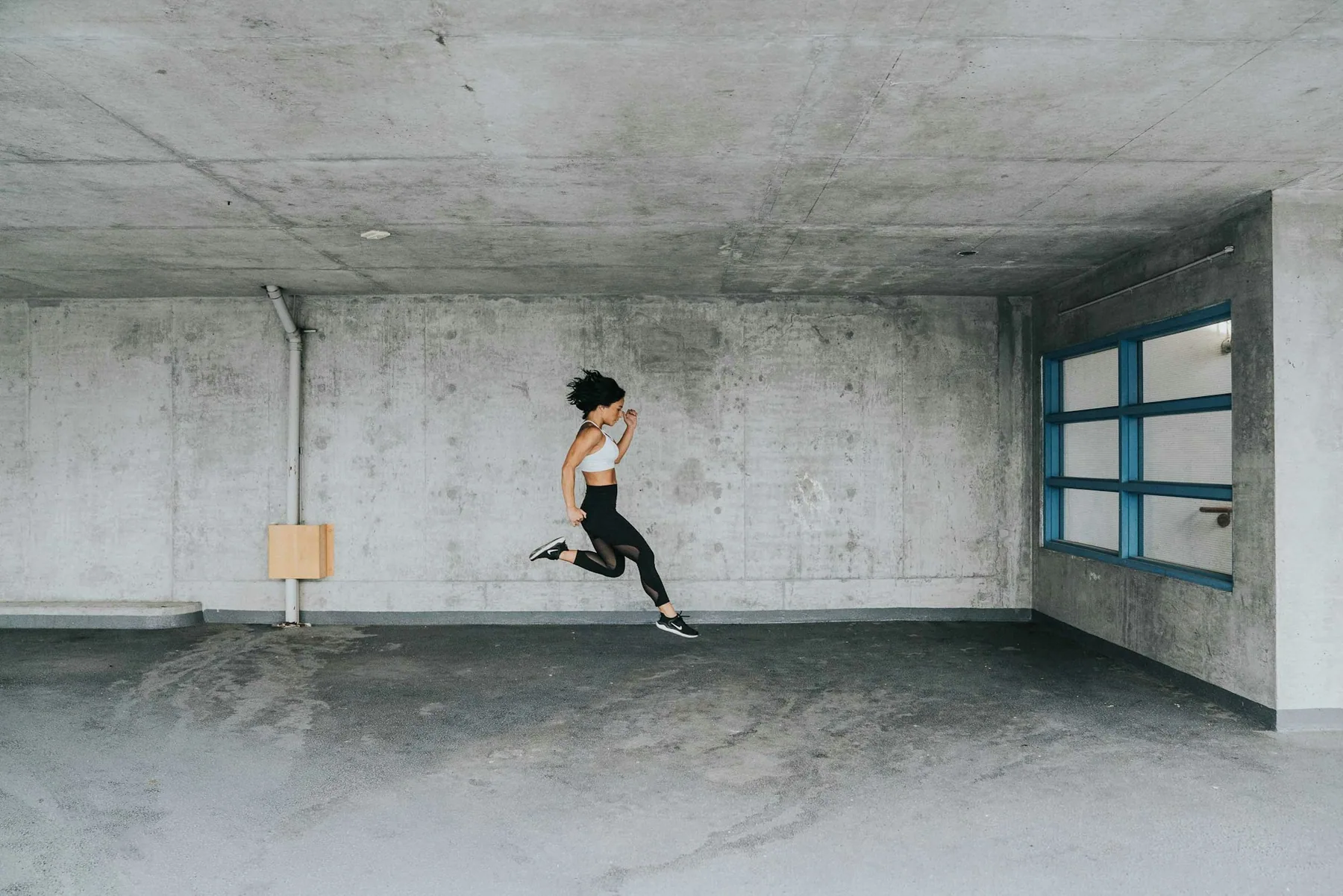 Someone mid-jump in a bare interior