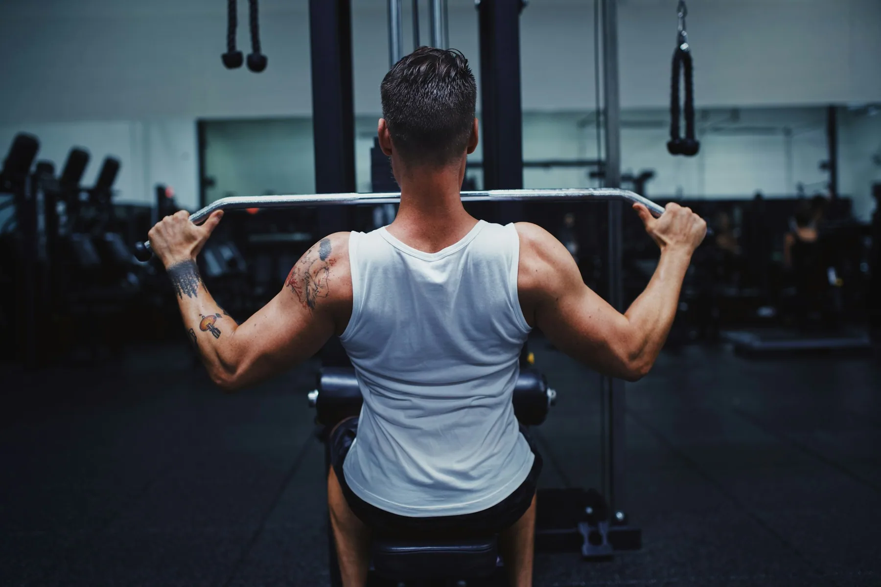 Rear view of an athlete pulling a bar down, shoulder blades visible