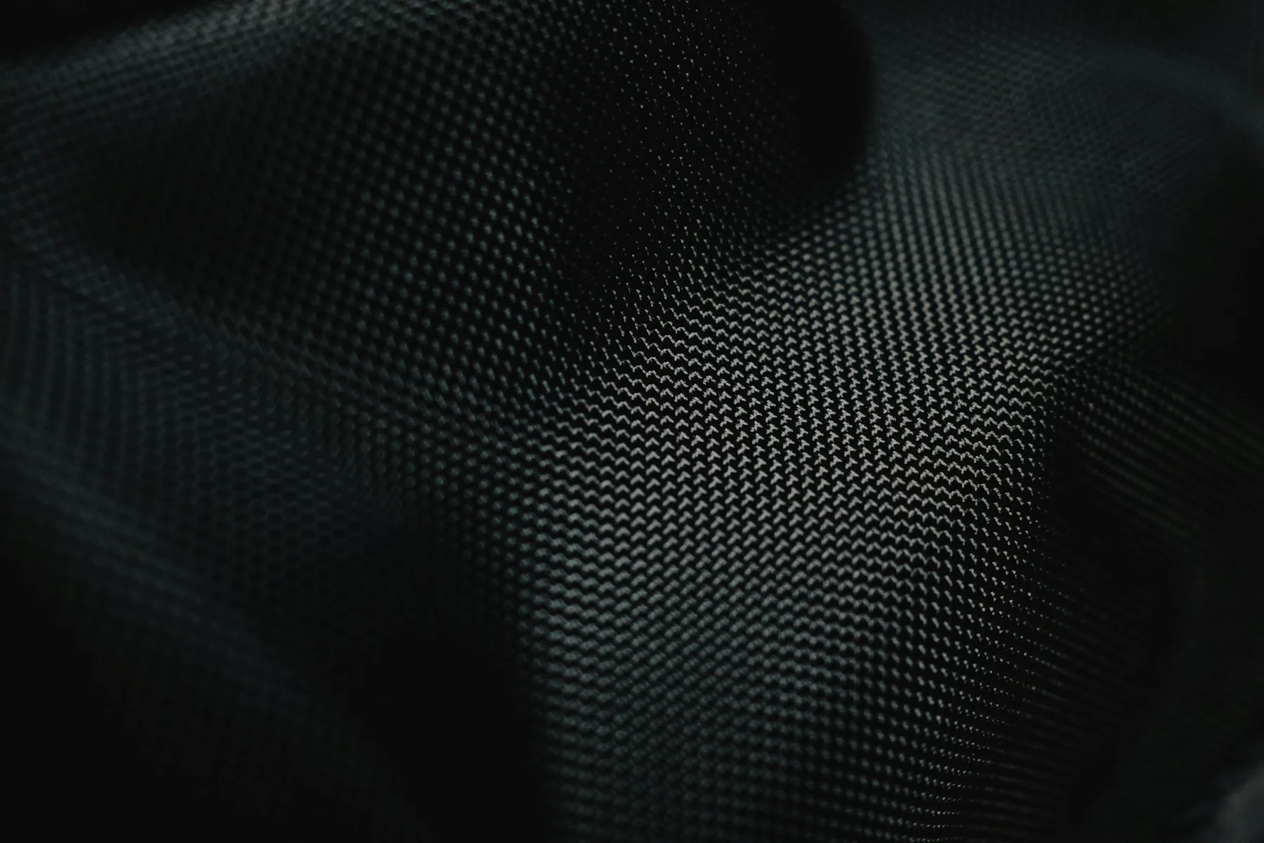 Macro detail of a dark performance mesh weave used in training shorts
