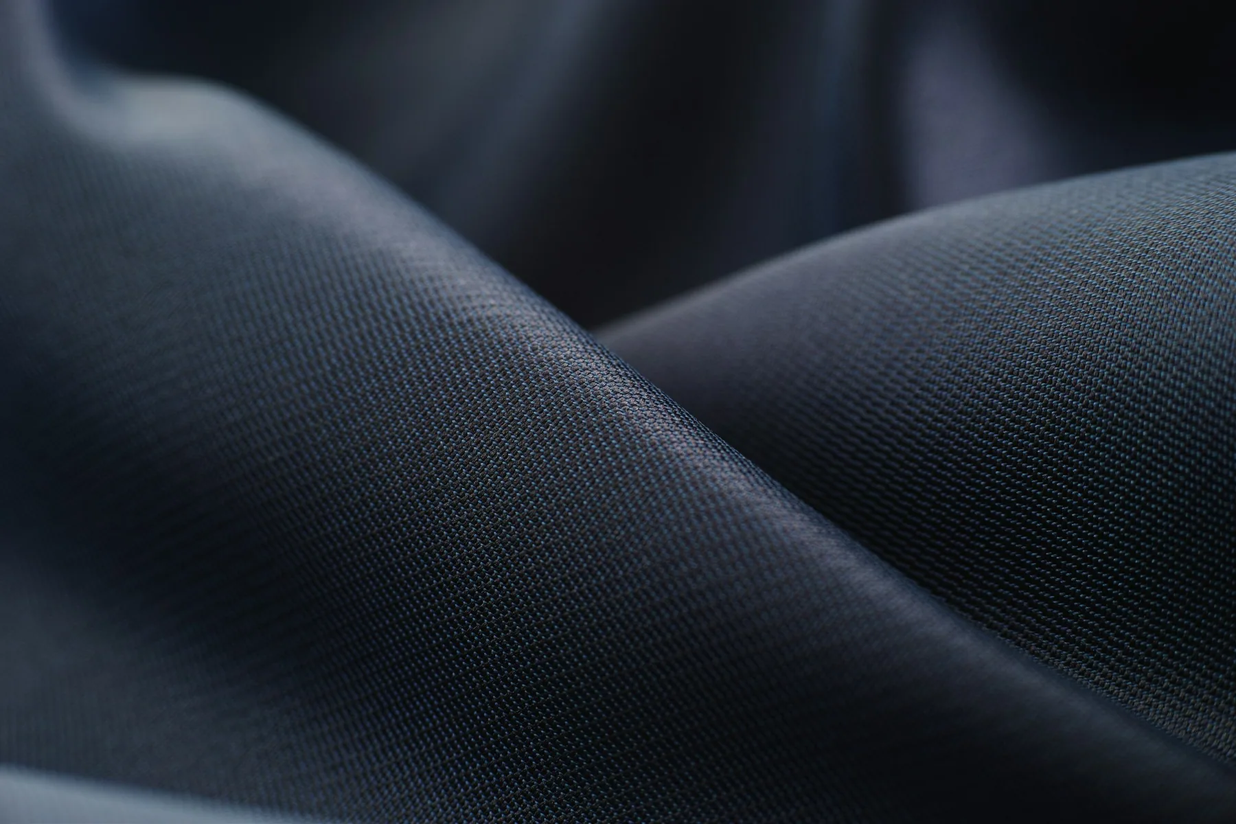Close detail of dark technical shorts fabric draped in soft folds