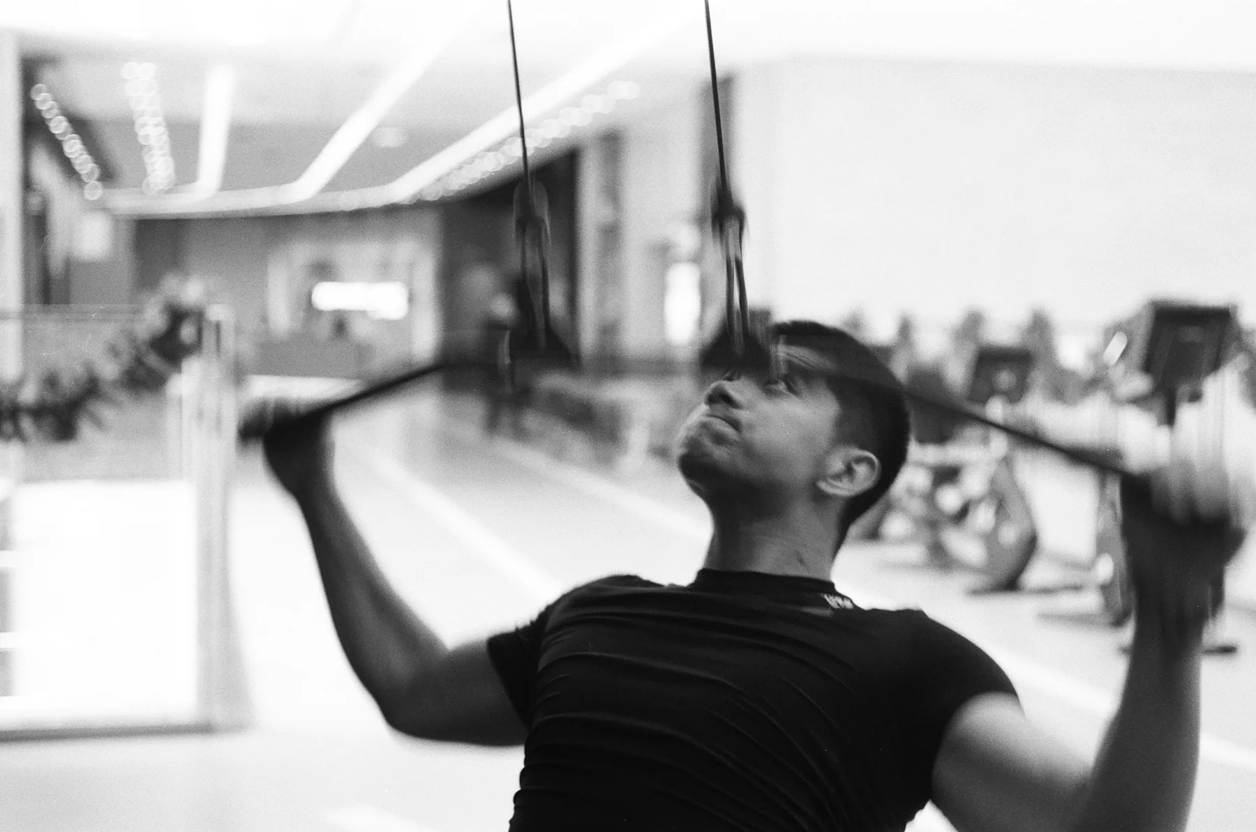 Athlete training at a cable machine, photographed in black and white