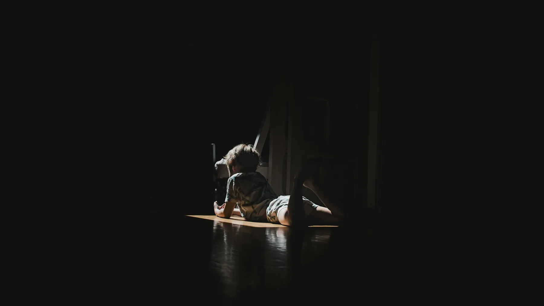 Someone lying on a mat in a dark room